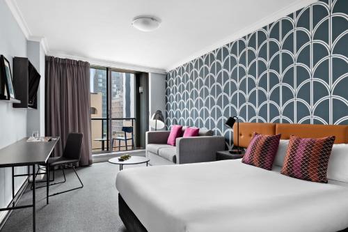 悉尼Mantra Sydney Central的酒店客房,配有床和沙发
