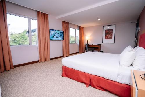 哥打巴鲁Jewels Hotel的酒店客房设有一张大床和窗户。