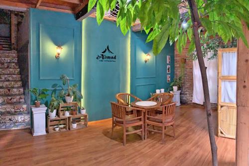 万隆Ahmad Lodge Garden View的蓝色墙壁的房间里一张桌子和椅子