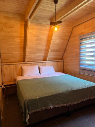 萨卡里亚Sapanca yeşilvadi 2+1 sıcak havuz,jakuzi,göl manzr的木制客房内的一间卧室,配有一张床