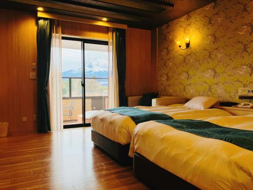 御殿场市Hotel Square FujiGotemba的酒店客房设有两张床和窗户。