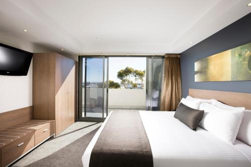 墨尔本Mantra Melbourne Airport的一间酒店客房,配有一张床和一台电视