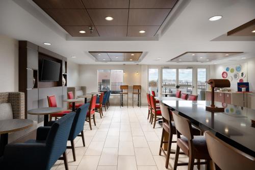 HixsonHoliday Inn Express & Suites Chattanooga-Hixson, an IHG Hotel的一间带桌椅和电视的用餐室