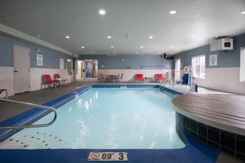 HixsonHoliday Inn Express & Suites Chattanooga-Hixson, an IHG Hotel的一个带红色椅子和桌子的大型游泳池