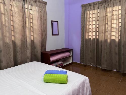巴东马士力OYO 90967 Homestay Chalet Warisan Siti的一间卧室配有一张带绿色枕头的床