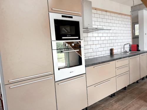ŽárUbytování JANOVKA的厨房配有白色橱柜和微波炉