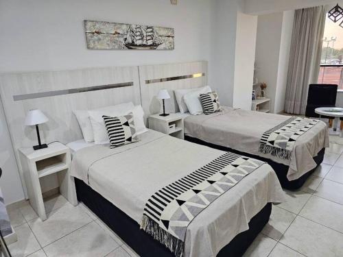 圣达菲Diseño y confort Monoambiente a pasos del Río!的配有两张桌子的酒店客房的两张床