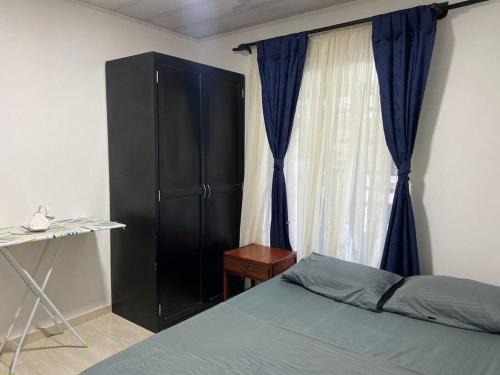 圣何塞德尔瓜维亚雷Cómoda casa cerca al centro的一间卧室配有一张床、一个黑色橱柜和一个窗户。