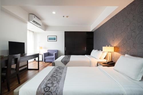曼谷Lily Hotel Bangkok的酒店客房配有两张床和一张书桌