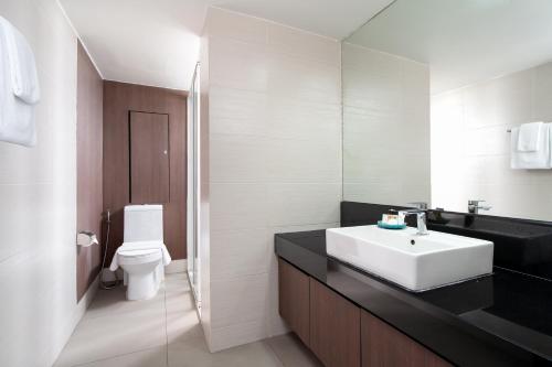 曼谷Lily Hotel Bangkok的浴室配有白色水槽和卫生间。