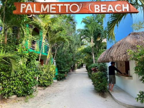 库尔克岛Palmetto Garden Cottage的站在种植园海滩度假胜地外的人