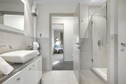皇后镇Distinctive Stylish and Spacious Family Home的白色的浴室设有水槽和淋浴。