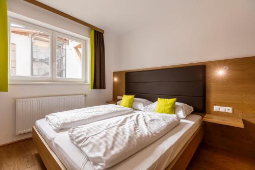 索内纳尔佩·纳斯费尔德Almresort Gartnerkofel by ALPS RESORTS的一间卧室配有一张带黄色枕头的大床