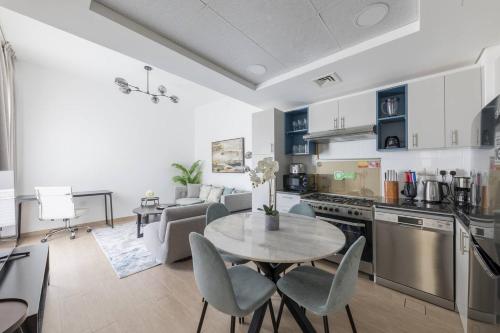 迪拜Comfortable 2bd Apartment Next To Metro & Mall的厨房以及带桌椅的起居室。