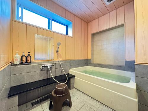 朝日Shiroyamasou的带浴缸和窗户的大浴室