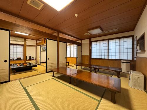 朝日Shiroyamasou的大房间设有木桌和窗户
