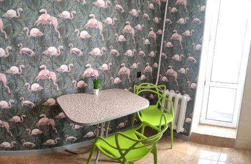 克列缅丘格Smart Apartment на Соборной 23的一张桌子和椅子,配有粉红色的火烈鸟壁纸