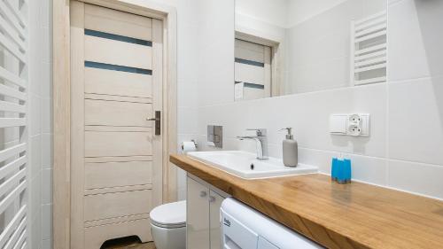 克拉科夫Apartamenty Sun & Snow Basztowa的白色的浴室设有水槽和卫生间。