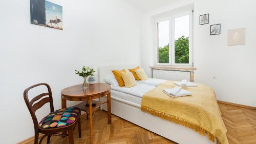 克拉科夫Apartamenty Sun & Snow Basztowa的一间卧室配有一张床、一张桌子和一个窗户。
