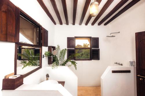 拉穆Pepo Villa, Anasa Hotels & Experiences的一间带两个盥洗盆和两个窗户的浴室