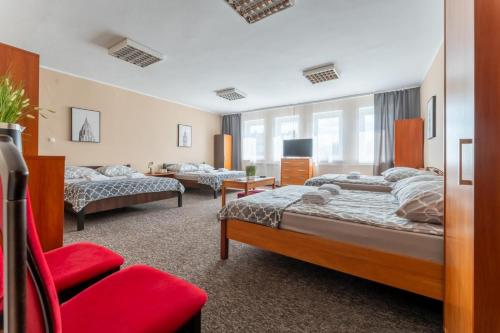耶莱尼亚古拉Hostello - Pokoje, Bilard, Ping-Pong, Parking - by SpaceApart的一间卧室配有两张床和红色椅子