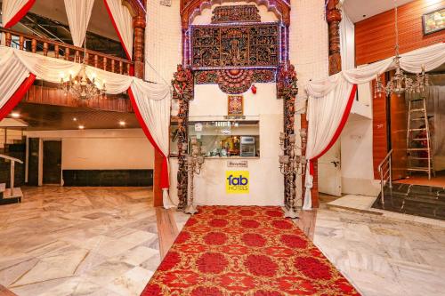 海得拉巴FabHotel Maruthi Residency的一间大房间,地板上铺有红色地毯