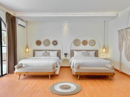 JetisTujuan Jogja Villas With Private Pool的卧室设有两张床,拥有白色的墙壁和木地板