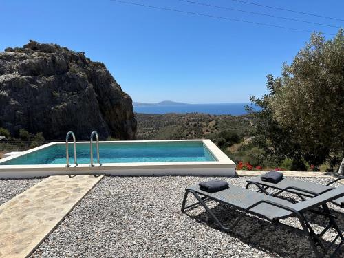 圣加利尼Vrachos Luxury Home 3, private pool!的一个带两把椅子和一张桌子的游泳池