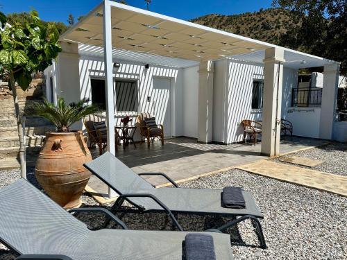 圣加利尼Vrachos Luxury Home 3, private pool!的一个带椅子的庭院和一个带桌子的凉亭