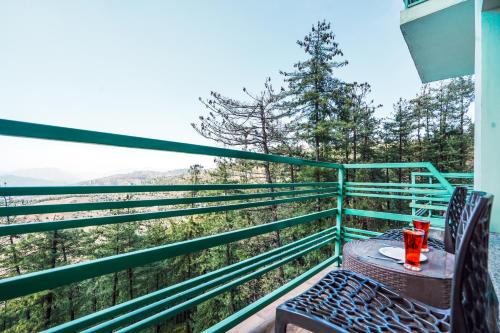 西姆拉Green Valley Resort Mashobra By AN Hotels的美景阳台配有桌椅