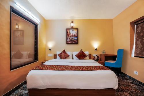 西姆拉Green Valley Resort Mashobra By AN Hotels的酒店客房带大床和蓝椅