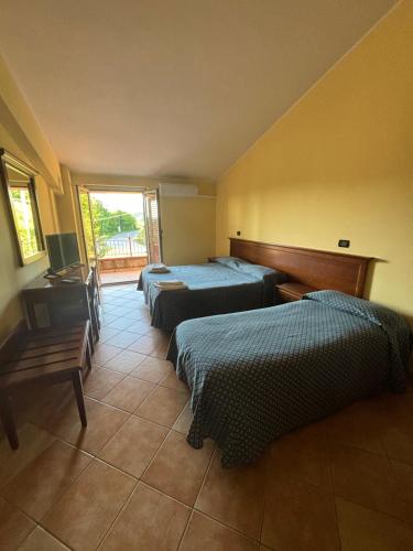 OrsomarsoLa nuova locanda的一间卧室设有两张床和窗户。