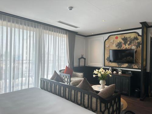 河内Luxe Paradise Premium Hotel的一间卧室配有一张床、一张沙发和一台电视。