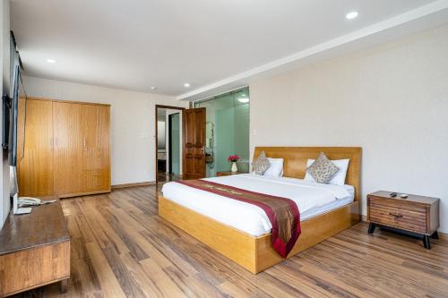 胡志明市La Palma - Garden Saigon Hotel Phu My Hung的一间卧室配有一张大床和电视