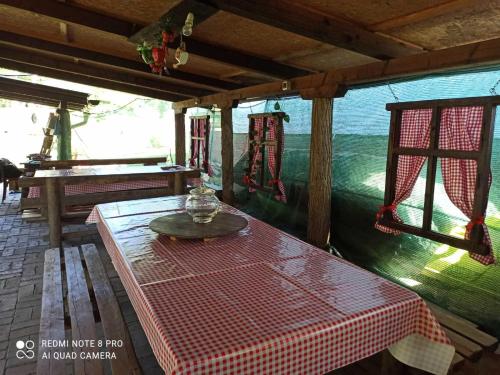 NeštinMini-Camp SKELICA的门廊上一张桌子,上面有红白的桌布
