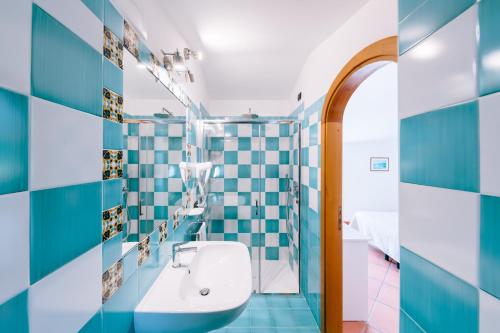 斯卡拉Albergo La Margherita的浴室拥有蓝色和白色的瓷砖墙壁和水槽