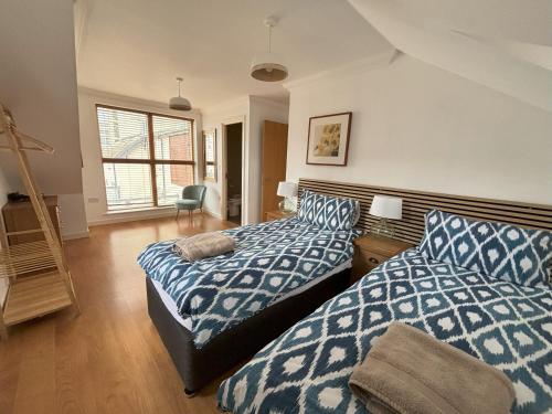 伊斯特布恩Millgrove House Apartments的一间卧室配有两张带蓝白色床单的床