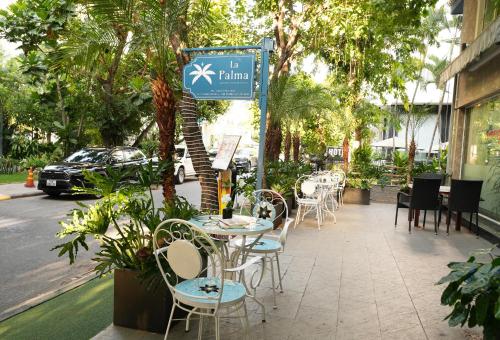 胡志明市La Palma - Garden Saigon Hotel Phu My Hung的街道旁人行道上的桌椅