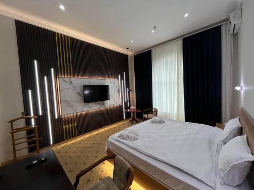 撒马尔罕梅克斯特皇宫酒店的一间卧室配有一张床和一台平面电视