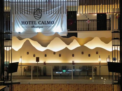 新加坡Hotel Calmo Chinatown的酒店大堂的墙上挂有酒店卡松标志