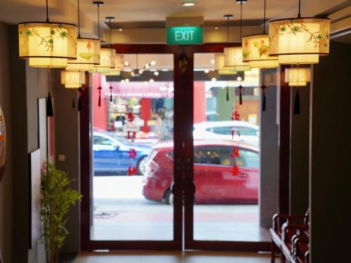 新加坡Hotel Calmo Chinatown的外面有红色汽车的商店的门