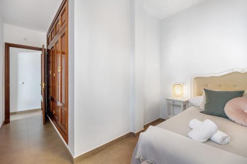 奇克拉纳－德拉弗龙特拉Piso arquillo del reloj的一间卧室配有一张床,上面有两条毛巾