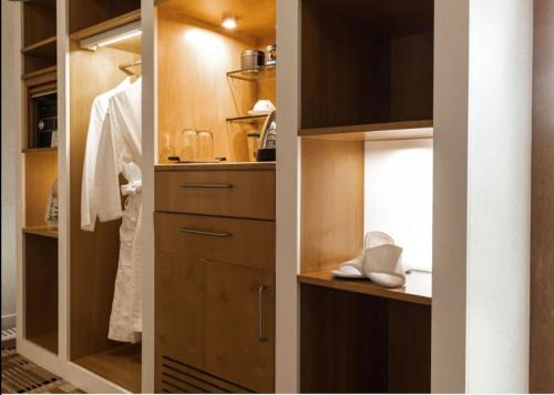 霍巴特Islington Hobart - Wellington Suite - Australia的浴室设有步入式衣柜和木制橱柜。
