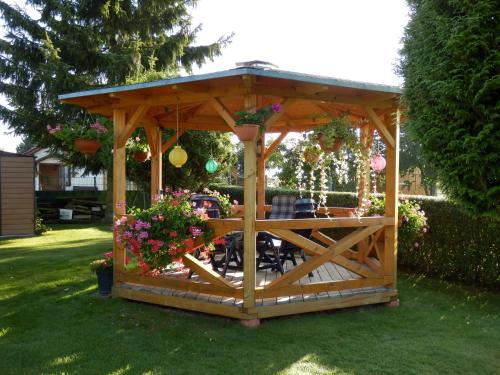 GotthunFerienwohnung unweit der Müritz的庭院里种满鲜花的木制凉亭