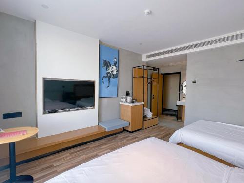 济阳银座佳驿精致酒店（济阳汽车总站店）的一间卧室配有一张床和一台平面电视