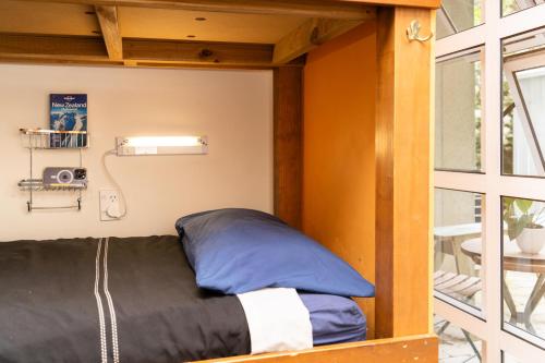 奥克兰哈卡小屋奥克兰旅舍的一个小房间的一个床位,设有窗户