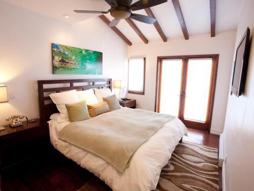 阿瓦隆Amazing Luxury ocean front Hamilton Cove Villa welectric cart的一间卧室配有一张大床和吊扇