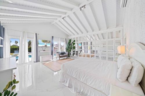 努尔德Caya Mesa Bista 40 Tierra del Sol的一间白色的卧室,配有床和客厅