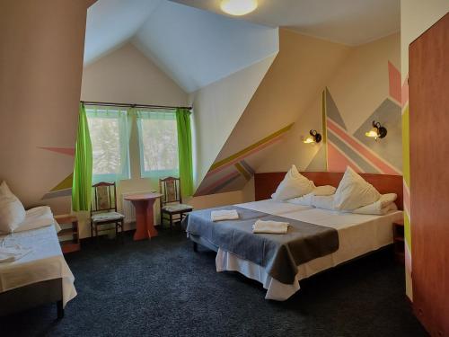卡尔帕奇DW米喜客酒店的一间设有床铺和两把椅子的房间