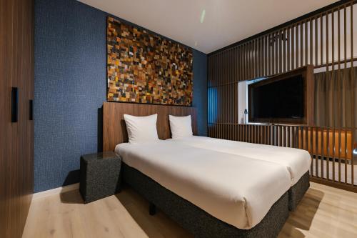 阿姆斯特尔芬阿姆斯多芬服务式公寓酒店的一间卧室配有一张大床和电视